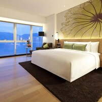 Una habitación de hotel moderna con una cama grande, vista al mar y una pieza decorativa en la pared.