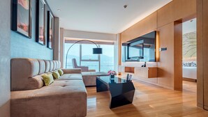 A modern living room with a sofa, a coffee table, and a view of the outdoors. - Wingtech Hotel (Huangshi)