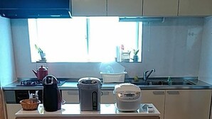 Une cuisine dotée d’un îlot central, d’un évier et de trois poubelles.