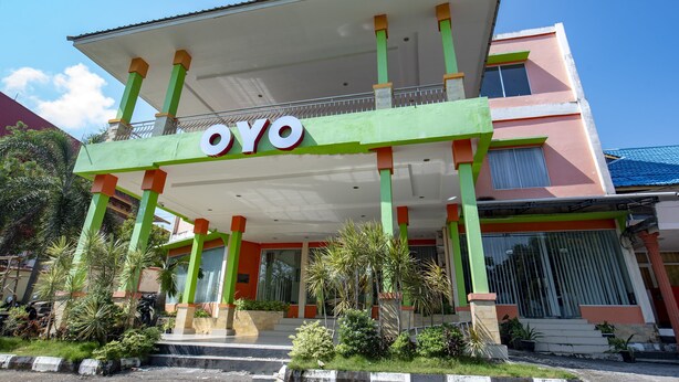 A building with a prominent "OYO" sign, a covered entrance area, and a staircase leading to the entrance. - OYO 1164 Edotel Mahligai By Smkn 2 Tanjung Pinang (Tanjung Pinang)