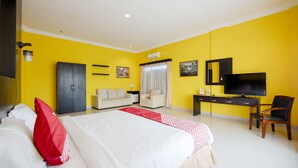 A hotel room with a bed, a desk, a chair, a wardrobe, a television, and a window with curtains. - OYO 1164 Edotel Mahligai By Smkn 2 Tanjung Pinang (Tanjung Pinang)