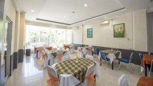 A spacious dining area with multiple tables and chairs, arranged in a U-shape, with a large window providing natural light. - OYO 1164 Edotel Mahligai By Smkn 2 Tanjung Pinang (Tanjung Pinang)