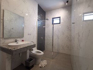 Une salle de bain moderne avec un lavabo, des toilettes et une douche en marbre.