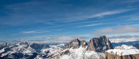 Eine verschneite Berglandschaft mit felsigen Gipfeln und blauem Himmel.