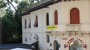 Un bâtiment doté de fenêtres en arc de cercle et d’une enseigne indiquant « Olimpia Italiana ».