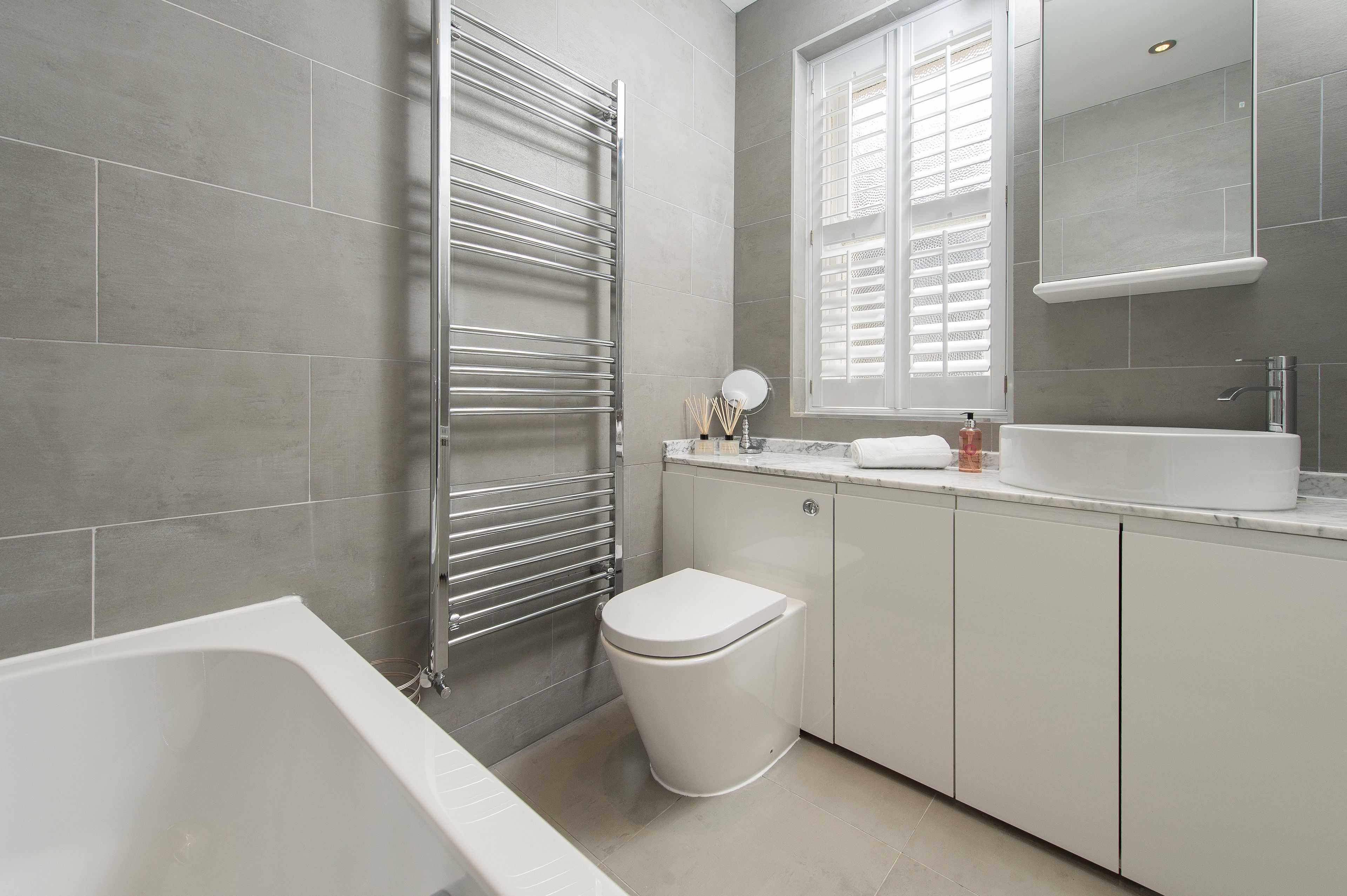 A modern bathroom with a bathtub, toilet, and vanity.