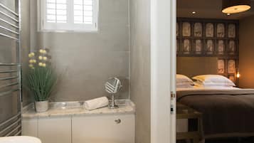 A bathroom with a marble countertop, a potted plant, a towel, and a mirror.