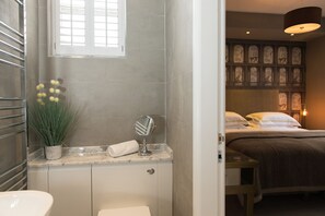 A bathroom with a marble countertop, a potted plant, a towel, and a mirror. - Belford (Harrogate)
