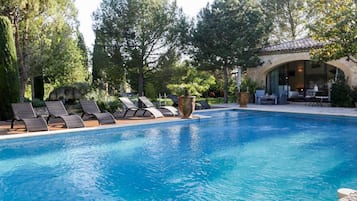 Una piscina al aire libre de temporada, tumbonas
