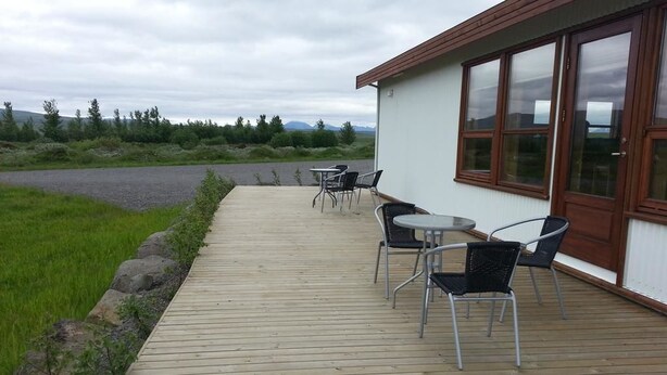 Eine Holterrasse mit Sitzgelegenheiten im Freien und ein Gebäude mit großen Fenstern.