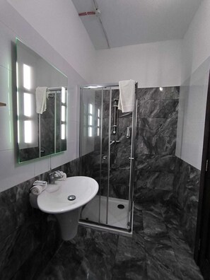 Superior kamer | Badkamer | Een douche, een haardroger, handdoeken, zeep