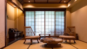 A traditional Japanese room with tatami flooring, two wooden chairs, a low wooden table, and a shoji screen window. - Ancient Hotel asama karuizawa (Karuizawa)