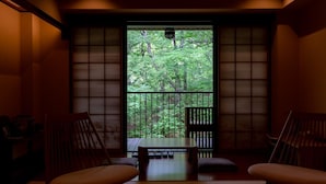 A traditional Japanese room with tatami flooring, a low wooden table, and two wooden chairs. - Ancient Hotel asama karuizawa (Karuizawa)