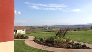 A rural landscape with a white building and a paved path leading to it. - Al Dolce Farniente (Marsciano)