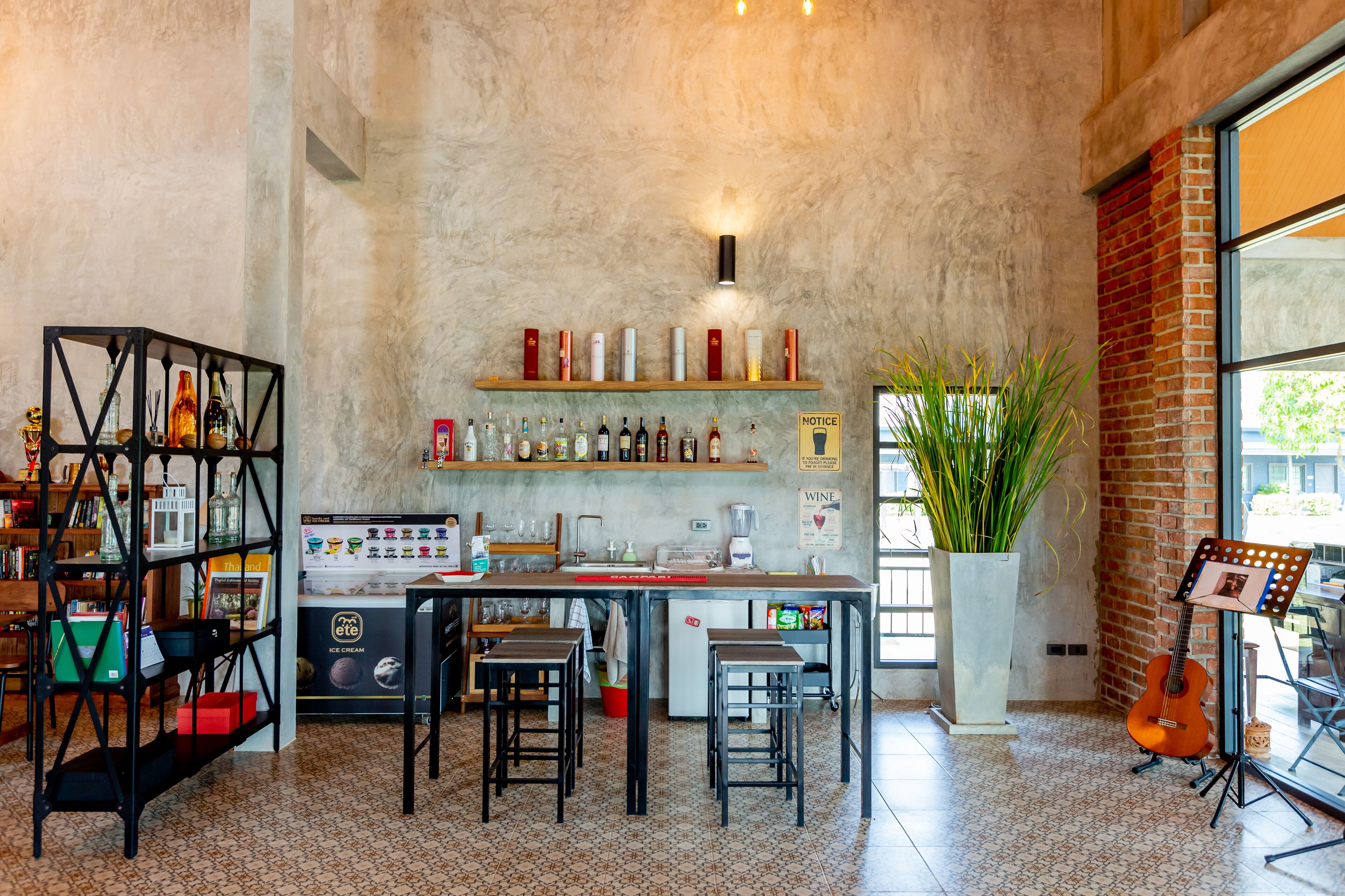 Una cocina moderna con barra, una planta grande en maceta y una guitarra.