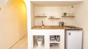 A compact kitchenette with a sink, wooden countertop, and a small refrigerator. - Kordela studios (Kassandra)