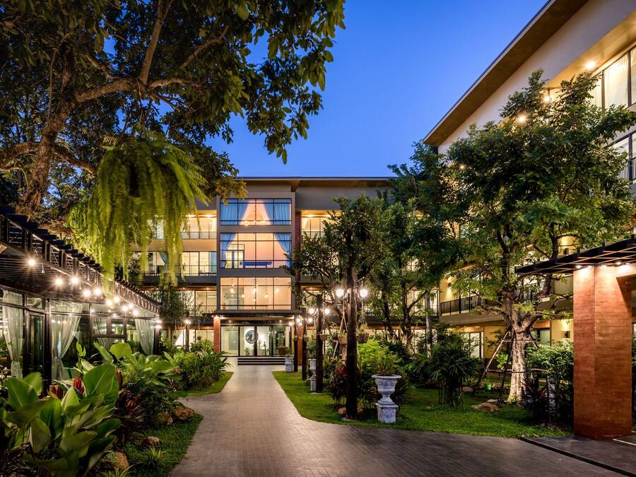 Ein modernes Hotel mit Innenhof, Glasfassaden und einem gut beleuchteten Eingang.