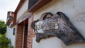 A sign with Chinese characters and a phone number attached to a wall. - Love nostalgia No. 53 B&B (Jincheng)