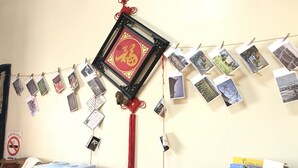 A wall with a red Chinese character decoration, a string of photos, and a water dispenser. - Love nostalgia No. 53 B&B (Jincheng)