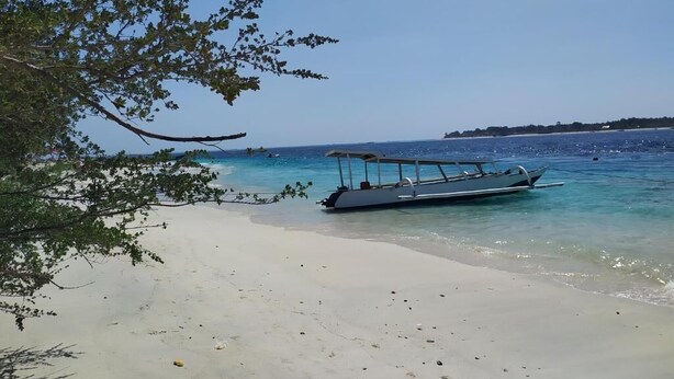 A beach with a boat docked near the shore.