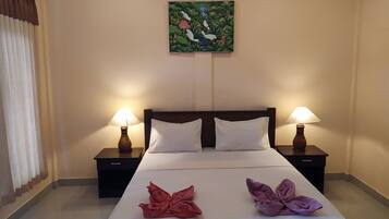 A hotel room with a bed, two nightstands, two lamps, a painting on the wall, and two towels on the bed.