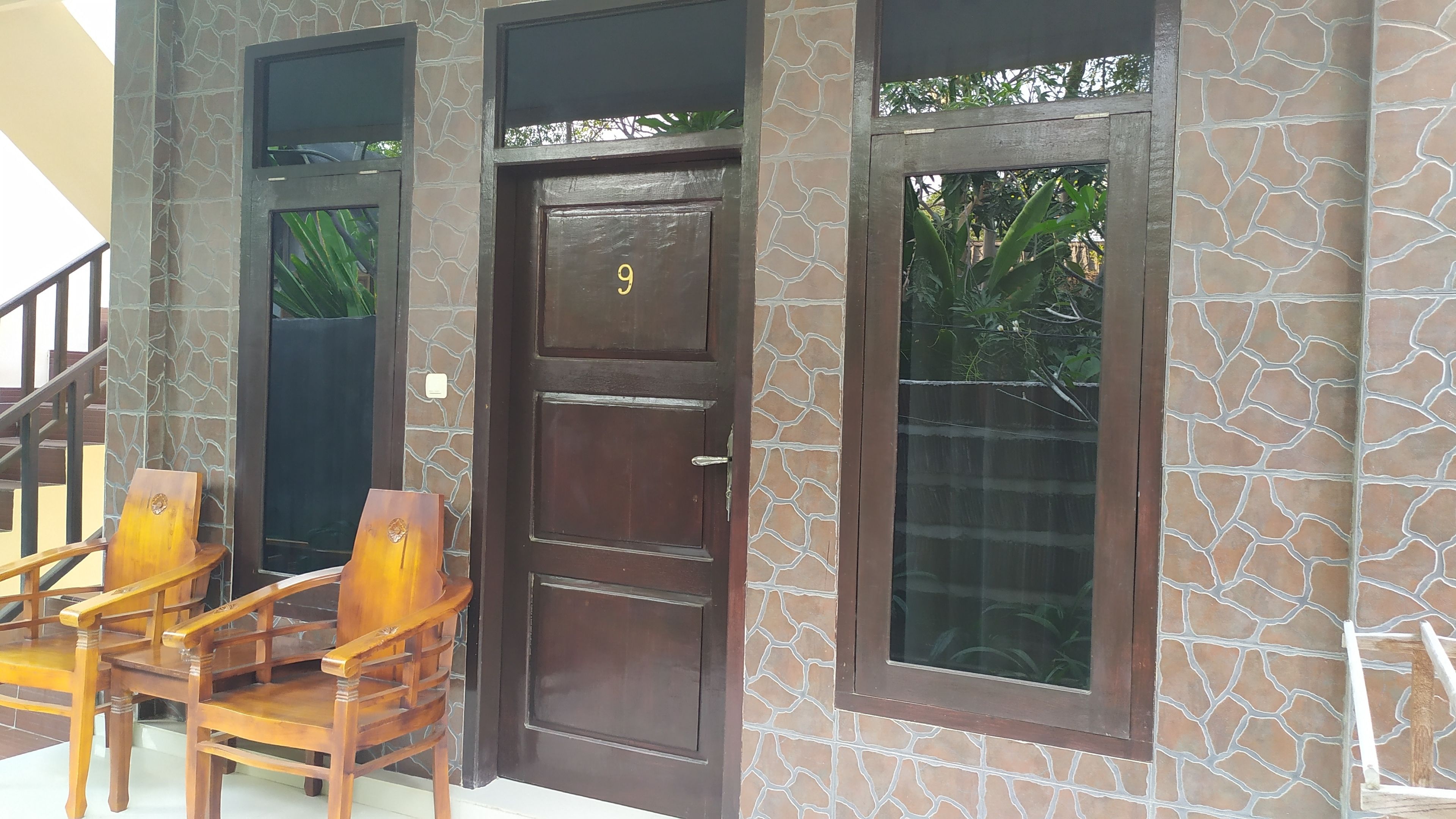 A wooden door with a number '9' and a window with a stone pattern.