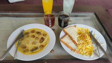 A meal tray with two plates of food, a drink, and a cup.
