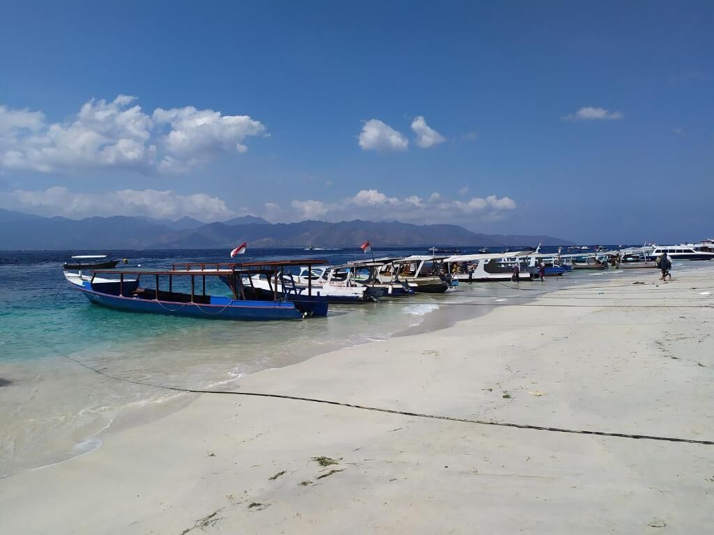 A beach with boats docked and a clear sky.