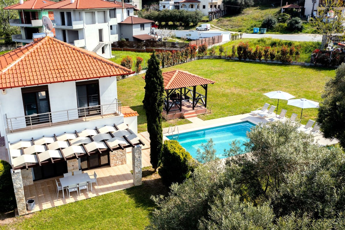 A residential property with a swimming pool, outdoor seating, and a garden.