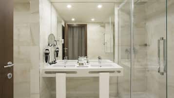 A modern bathroom with a glass-enclosed shower, a double sink vanity, and a large mirror.