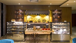 A bakery display with various baked goods and pastries. - Regenta Central Noida (Noida)