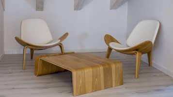 A minimalist room with two wooden chairs and a wooden coffee table.