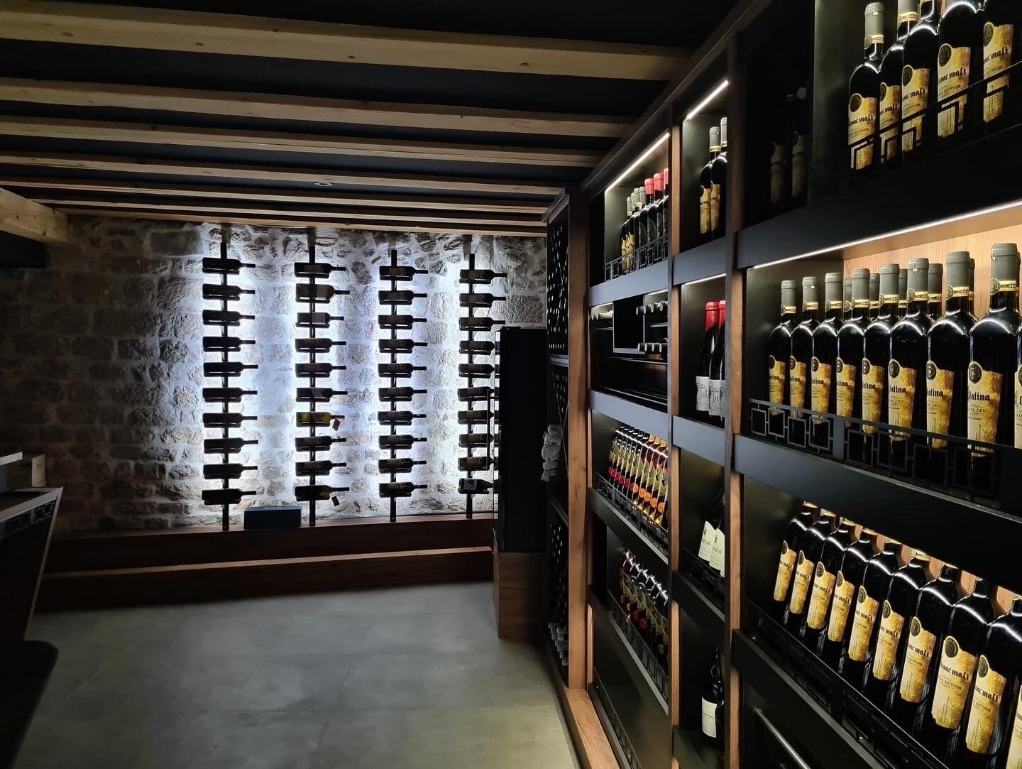 Una bodega con estantes de madera y una pared de piedra.