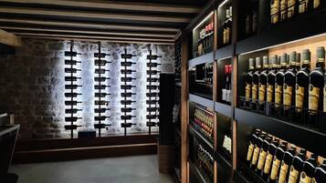 Una bodega con estantes de madera y una pared de piedra.