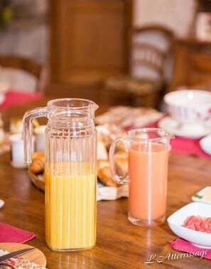 Una mesa de desayuno con una jarra de jugo de naranja y un vaso de jugo de naranja.