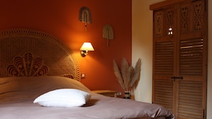 A bedroom with a wooden headboard, a bedside lamp, a wooden nightstand, and a wooden wardrobe. - L'Atterrissage (Santes)