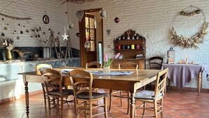 A dining area with a brick wall, wooden furniture, and a tiled floor. - L'Atterrissage (Santes)