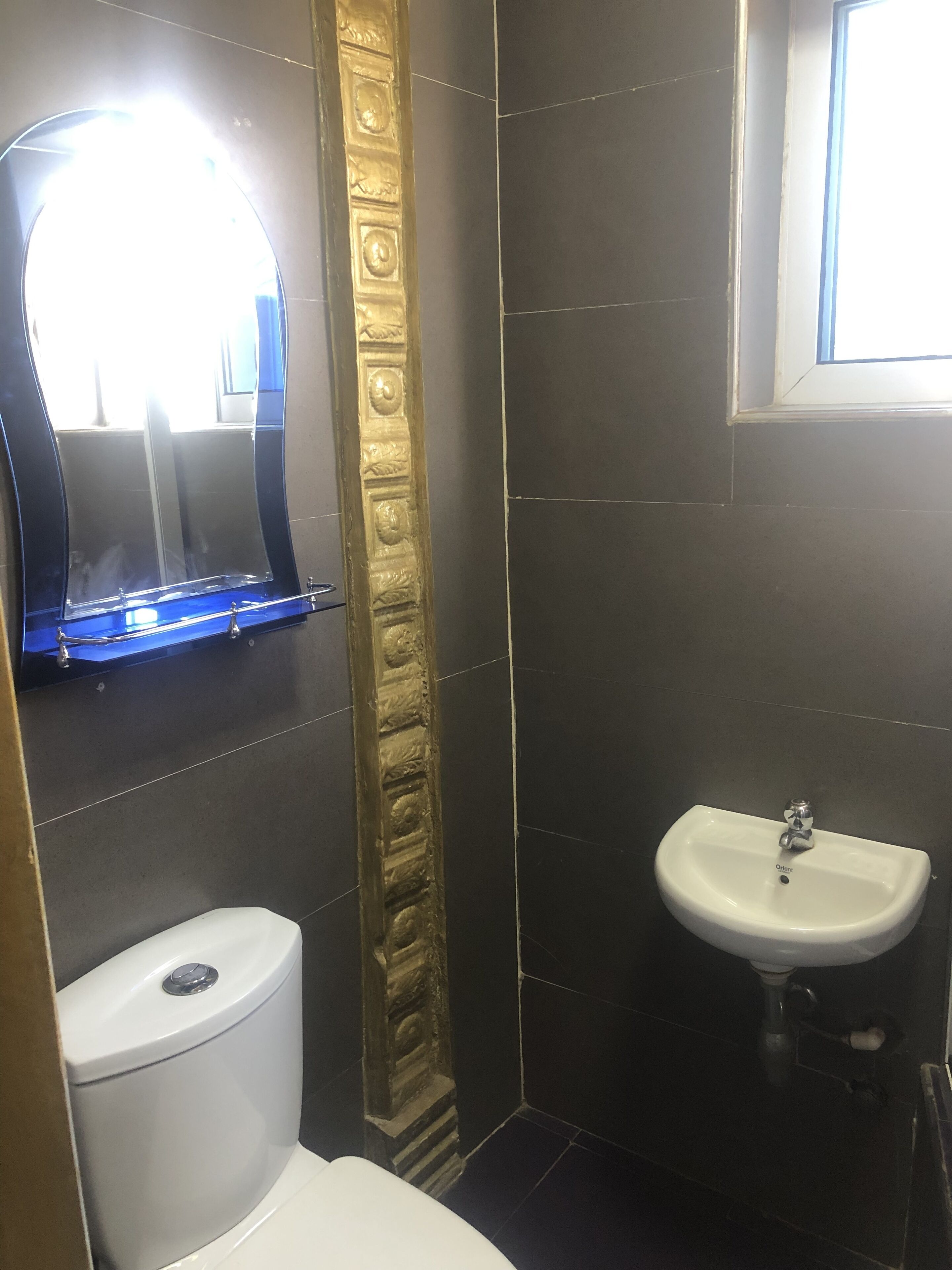 A bathroom with a toilet, a sink, and a mirror.