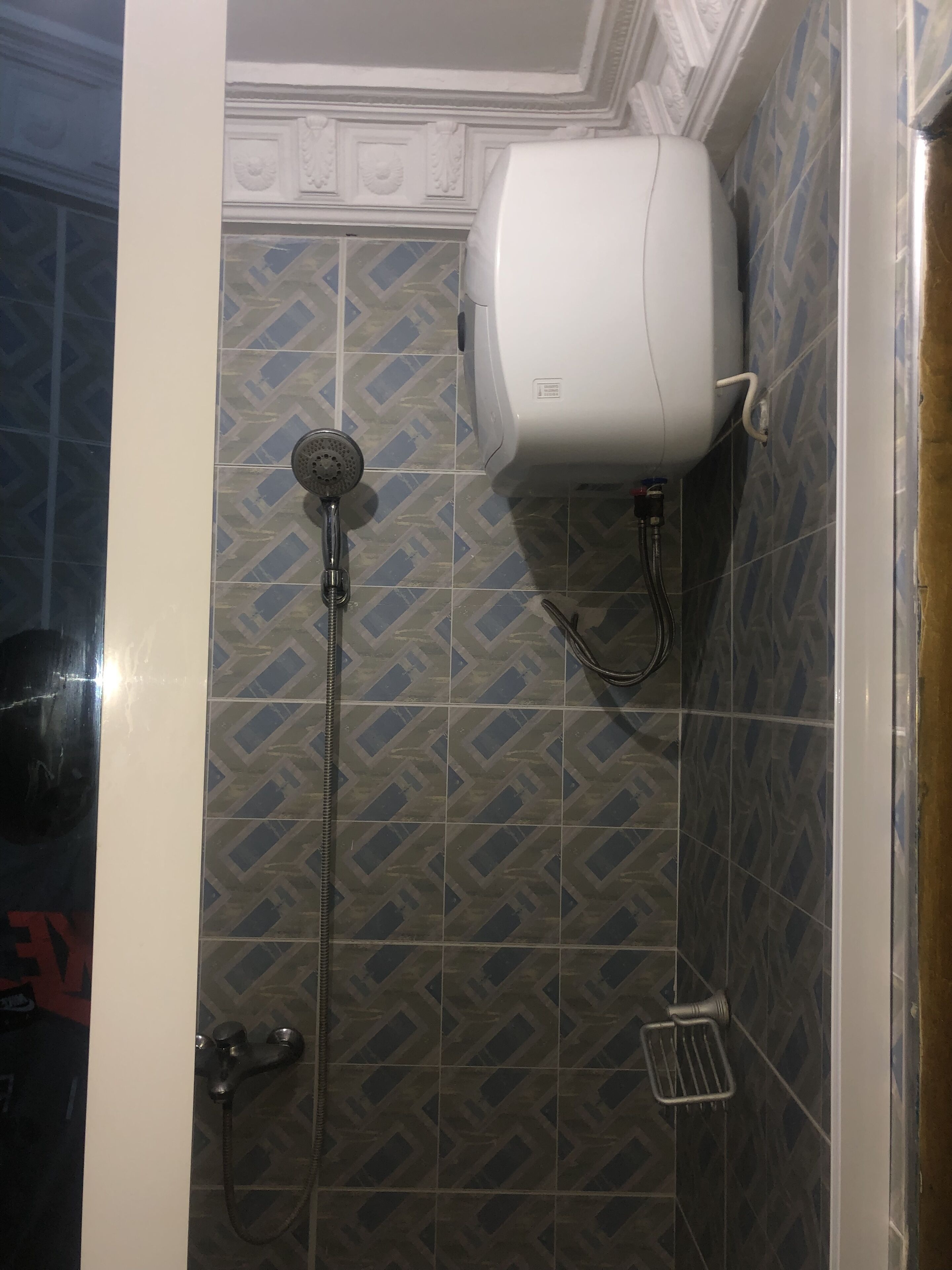 Dutxa amb plat de roba i assecador de mans fixat a la paret.