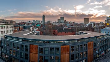 A modern building with a curved roof, surrounded by other buildings and a cityscape.