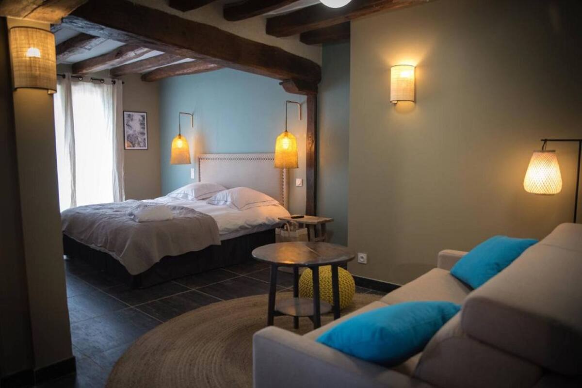 Une chambre avec deux lits, un canapé et une petite table.