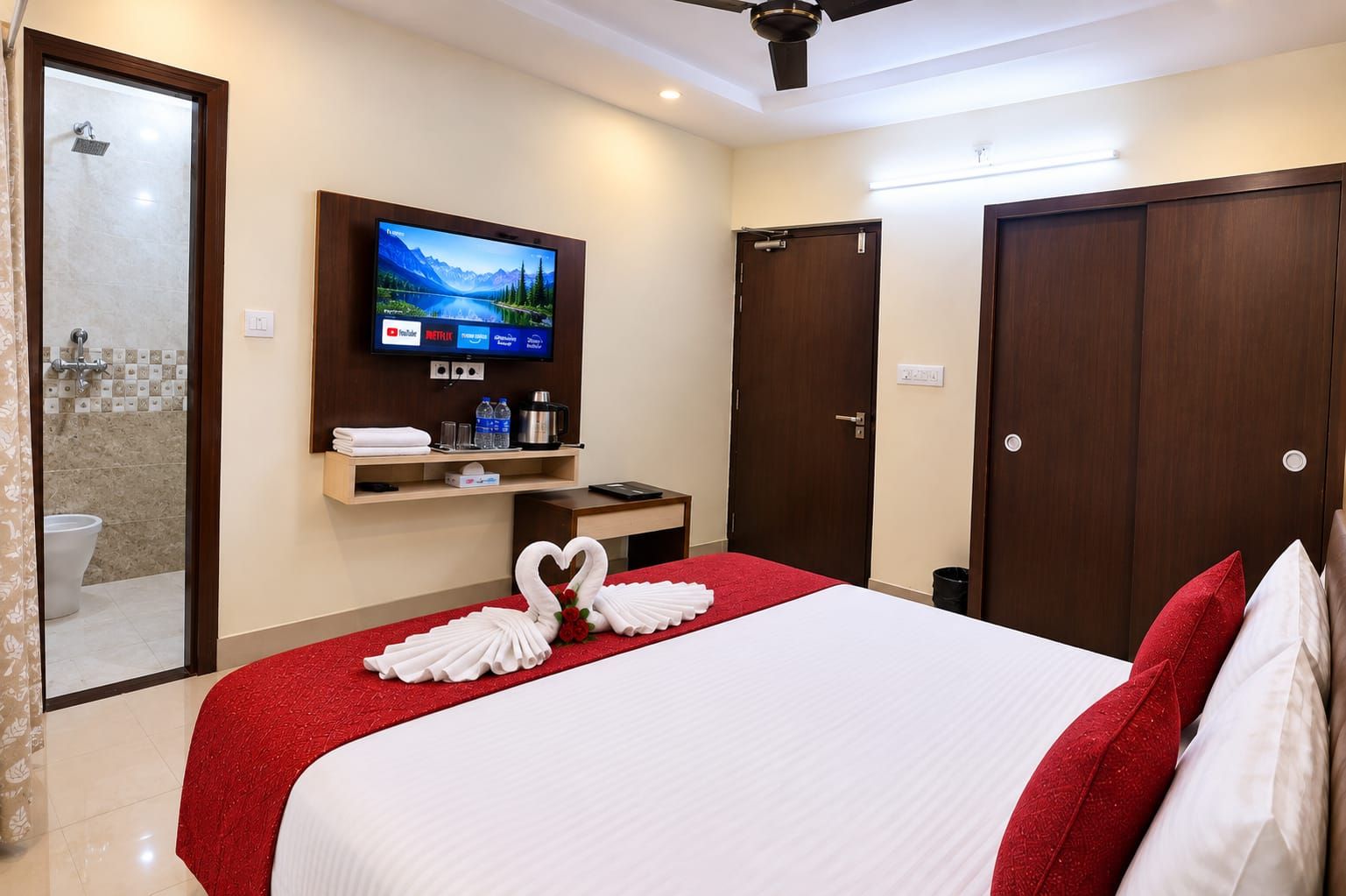 Una camera d'albergo con un letto, una televisione, una doccia e un armadio.