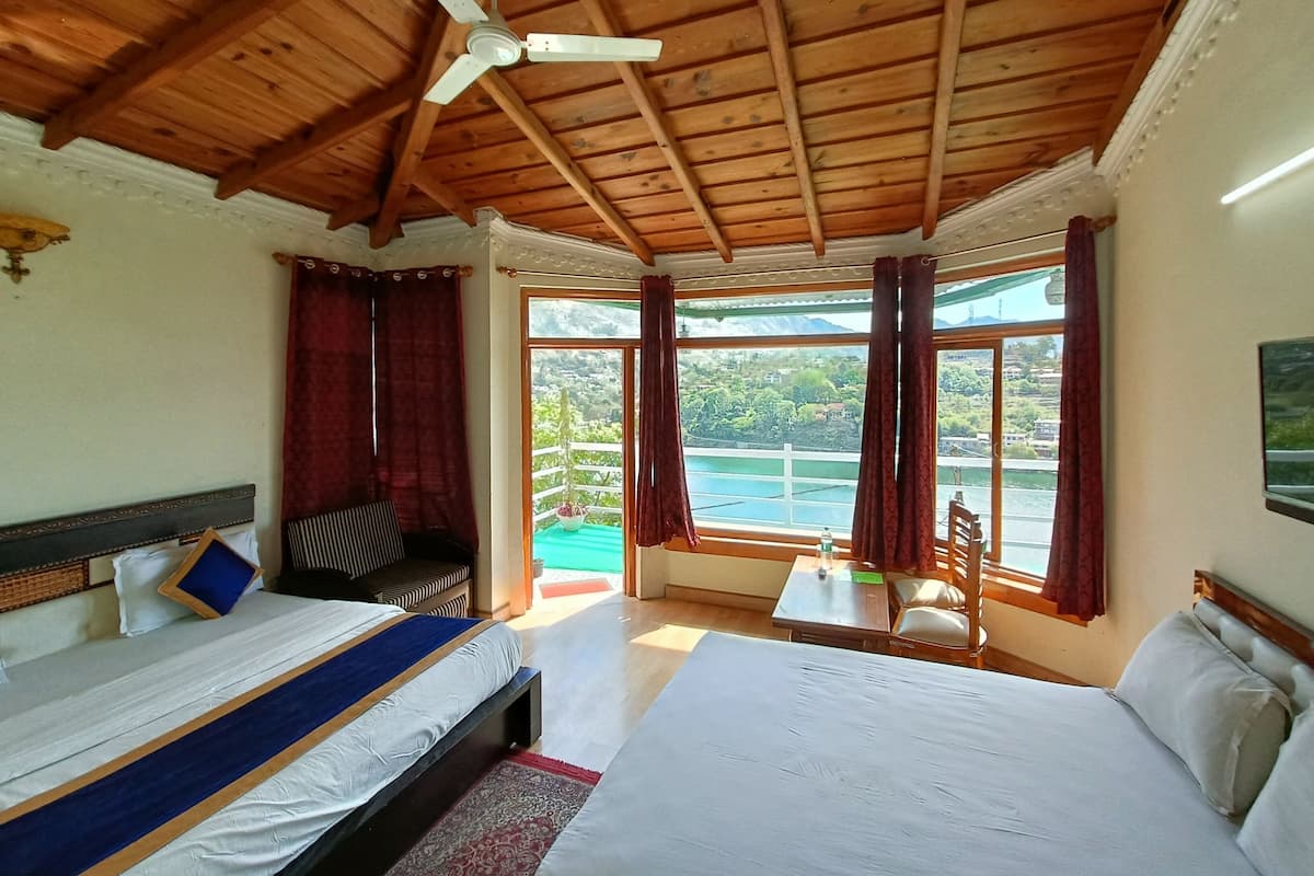 A bedroom with a bed, a chair, a table, and a ceiling fan.