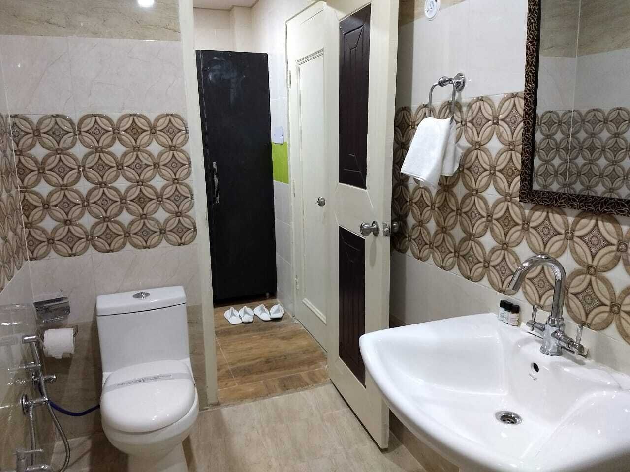 A bathroom with a toilet, sink, and shower area.