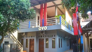 A two-story building with a balcony, a staircase, and a sign that reads "OYO". - OYO 1145 Rita Guesthouse (Pangandaran)