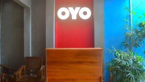 A reception desk with a red background and the word "OYO" in white letters. - OYO 1145 Rita Guesthouse (Pangandaran)