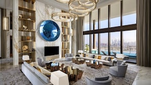 A spacious living room with a large window, a blue decorative sphere, and a city view.
