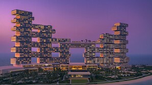 A modern hotel with a unique architectural design, featuring multiple levels and balconies, situated by the sea. - Atlantis The Royal (Dubai)