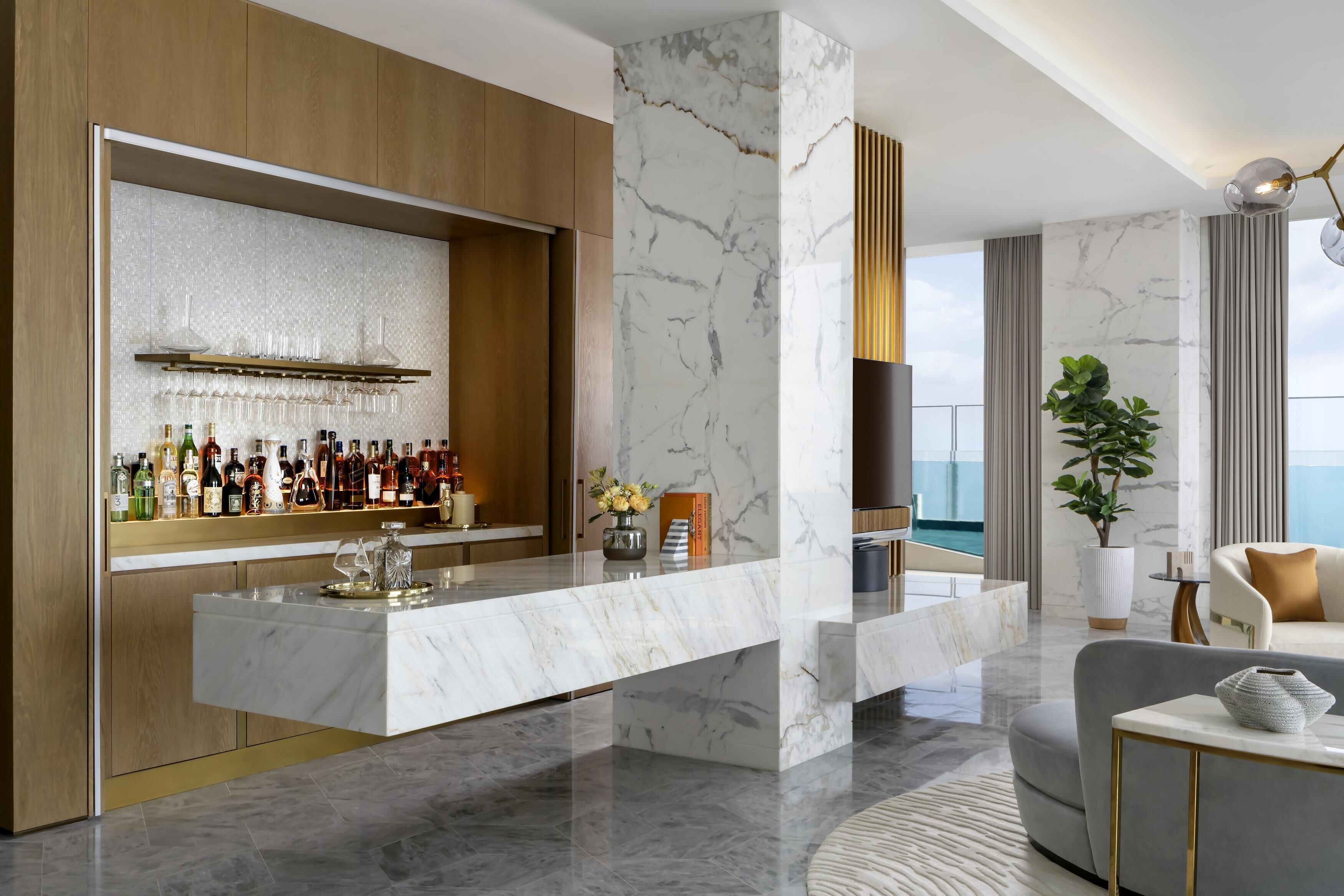 A modern interior with a marble bar, a sofa, and a view of the sea.