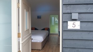 A bedroom with a bed, pillows, a nightstand, and a window. - MJP @ The Shepherds (Cambridge)